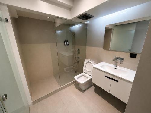 a bathroom with a shower and a toilet and a sink at The E-Hotel Makati in Manila