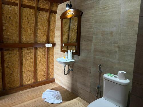 a bathroom with a toilet and a sink at Artala Villa & Restaurant in Besakih