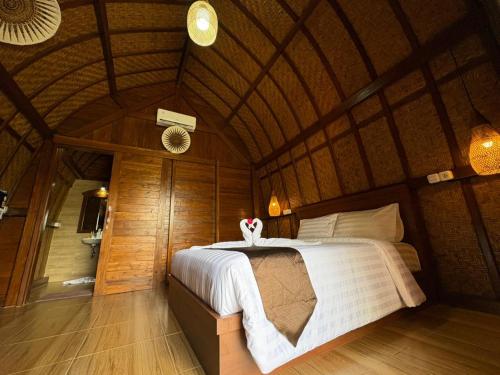 a bedroom with a bed in a wooden room at Artala Villa & Restaurant in Besakih