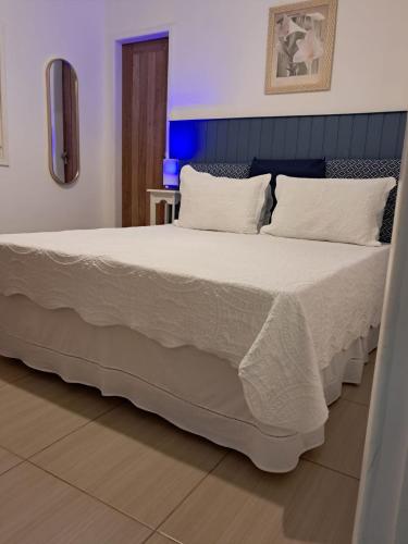 a bedroom with a large bed with white sheets and pillows at Pousada das Flores in Conservatória