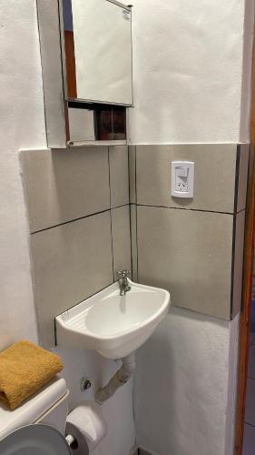 a bathroom with a sink and a toilet and a mirror at Casa los Molles Hostel in Maimará