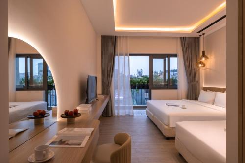 a hotel room with a bed and a tv at The Cozy Hotel in Ho Chi Minh City