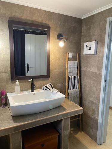 a bathroom with a sink and a mirror at Rustica Ocean View House in Bretanha