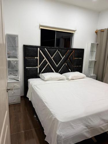 a bedroom with a large white bed with a wooden headboard at Casa en cineguilla in Cieneguilla