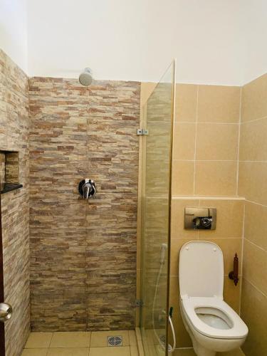 a bathroom with a toilet and a glass shower at Wanderlust at Golden Sun in Diani Beach