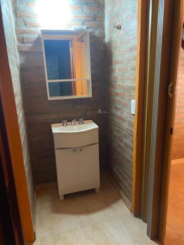 a bathroom with a sink and a mirror at Cabañas Frago in Villa Amancay