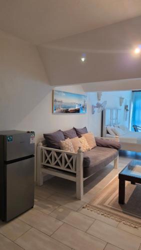 a living room with a couch and a refrigerator at Wanderlust at Golden Sun in Diani Beach