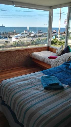 two beds in a room with a view of the ocean at Departamento Frente al Mar in Viña del Mar