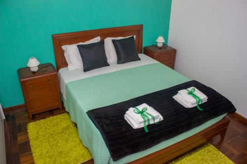 a bedroom with a bed with two towels on it at Escondidinho do Vez, LDA in Arcos de Valdevez