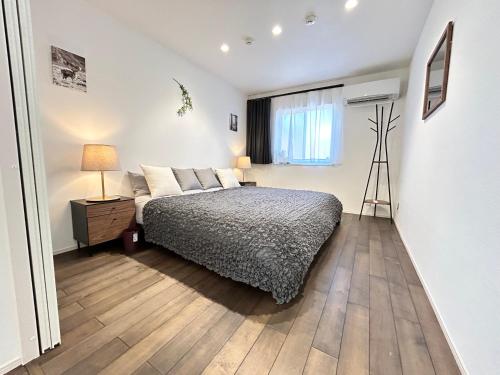 a bedroom with a bed and a window at 南アルプスを望むサウナ付き宿,田園風景,全室エアコン,バーベキュー可 in Hokuto