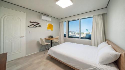 a bedroom with a bed and a window and a desk at Yangyang J Ocean View in Yangyang