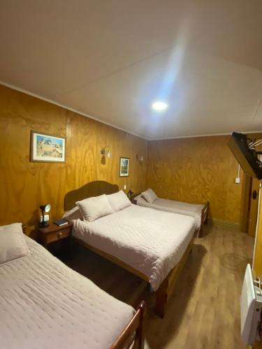 a hotel room with two beds and a television at HOTEL CASAGRANDE con estacionamiento EXCLUSIVO y estamos a 50 MTS del Terminal de Buses in Valdivia