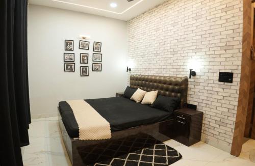 a bedroom with a bed against a brick wall at The White Lilly in Noida