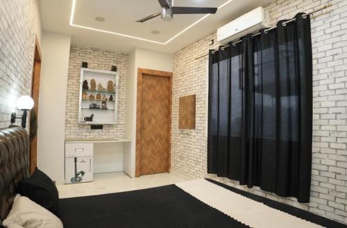 a room with a black curtain and a brick wall at The White Lilly in Noida