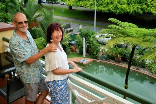 a man and a woman standing next to a pool at Waterfront Terraces in Cairns