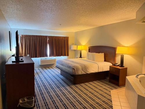 a hotel room with a bed and a window at AmericInn by Wyndham Kearney in Kearney