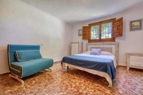 a bedroom with a bed and a chair at villa cap marti in El Tosalet