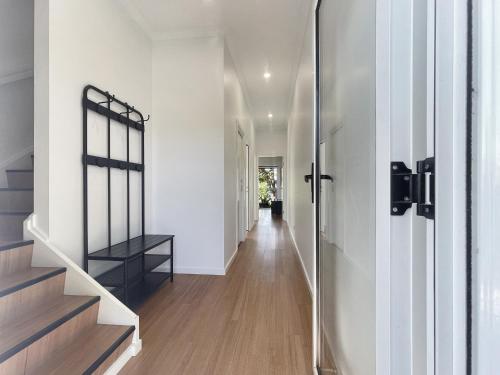 a hallway of a house with white walls and wooden floors at Pet-Friendly 3-Bed Coastal Gem Near Long Beach in Long Beach