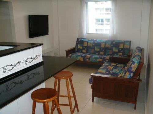Apartamento Charmoso no Guaruja في غوارويا: غرفة معيشة مع أريكة وطاولة وكراسي