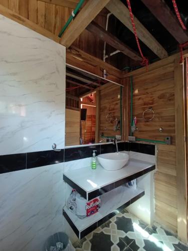 a bathroom with a sink in a room with wooden walls at Palmar Beach Cabañas - Bahía Rada in Moñitos