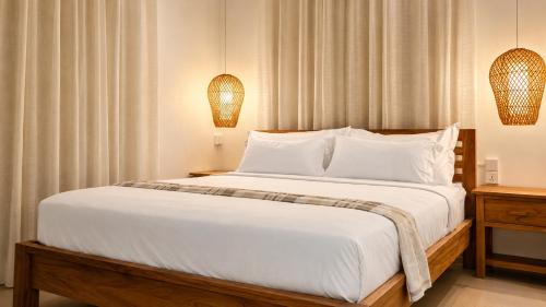 a bedroom with a large white bed with two lamps at Villa Agata Mauritius in Mont Choisy