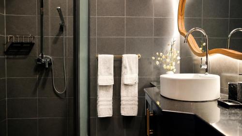 a bathroom with a sink and a shower with towels at Villa Agata Mauritius in Mont Choisy