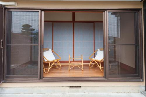 a screened porch with two chairs and a table at WTN Way too nice in Fujikawaguchiko
