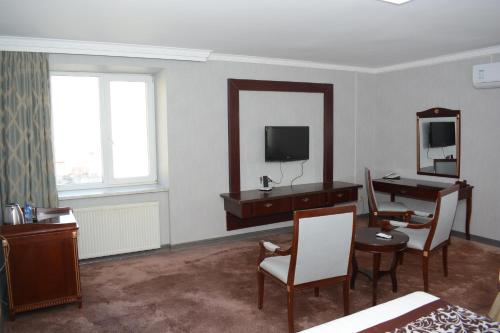 a hotel room with a desk and a mirror at White House Hotel in Ulaanbaatar