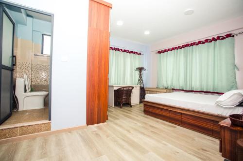 a bedroom with a large bed and a bathroom at Jhigu Casa Homestay in Kirtipur