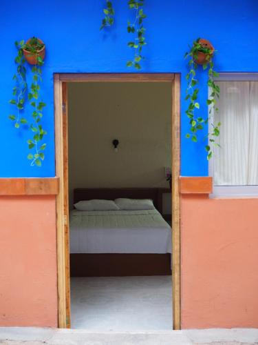 a bedroom with a bed in a blue wall at Hotel Don Candido in Tuxtla Gutiérrez