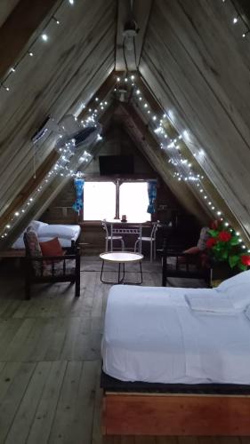 a room with two beds and a table in a attic at Mi Terraza Hostel in Almirante