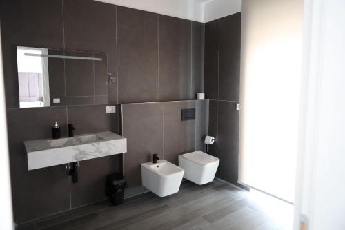 a bathroom with a toilet and a sink and a mirror at Airport bari grey in Bari