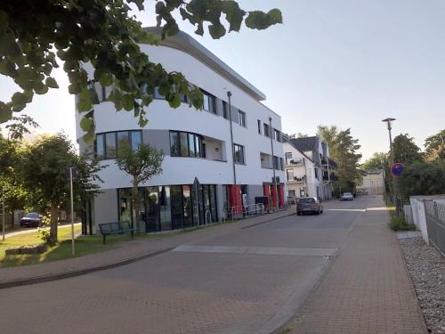 a white building on the side of a street at Appartement Am Sandhuf in Lubmin