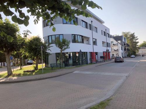 a white building on the side of a street at Panorama Suite in Lubmin