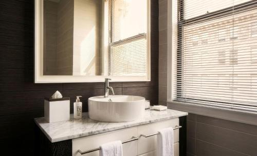 a bathroom with a white sink and a window at Hotel Clark in Los Angeles