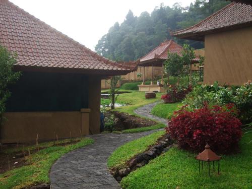 a garden with a walkway next to a house at Strawberry Hill Hotel & Restaurant in Bedugul