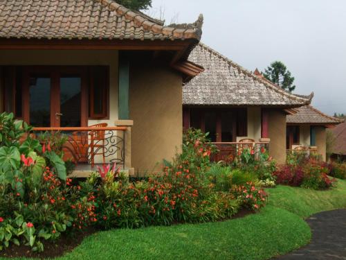 a house with a balcony and some flowers at Strawberry Hill Hotel & Restaurant in Bedugul