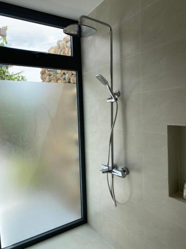 a shower with a shower head in a bathroom at Sunrise Beach House 1 in Tiến Thành