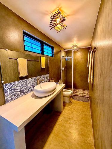 a bathroom with a sink and a toilet and a window at Beachfront Bungalows Bucana, El Nido in El Nido