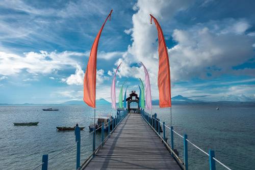 a wooden pier with flags on the water at Gangga Island Resort & Spa in Serai