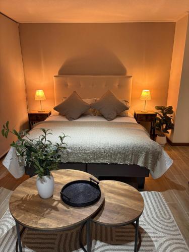 a bedroom with a bed with a table and two lamps at Nova Studio Dpto nuevo a pasos de Av Alemania in Temuco