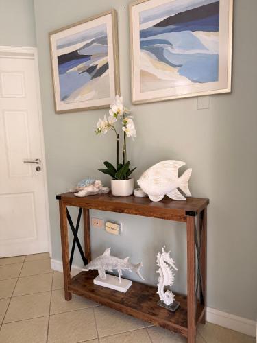 a wooden console table with a vase of flowers on it at Suite Escape Villa in Lowlands