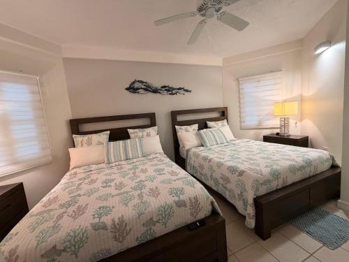 a bedroom with two beds and a ceiling fan at Suite Escape Villa in Lowlands