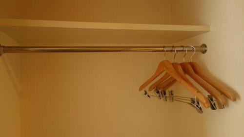 a closet with a rack of wooden hangers at Hotel Green Selec in Sendai