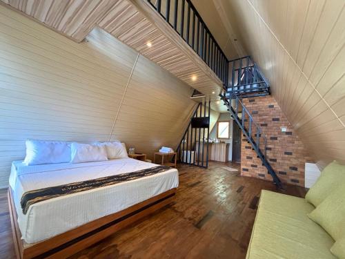a bedroom with a large bed and a staircase at Sinharaja Kithula Eco Cabanas in Batuwangala