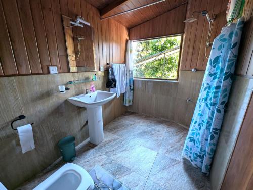 a bathroom with a sink and a toilet and a window at Ella Antara Green Wood Cottage in Ella