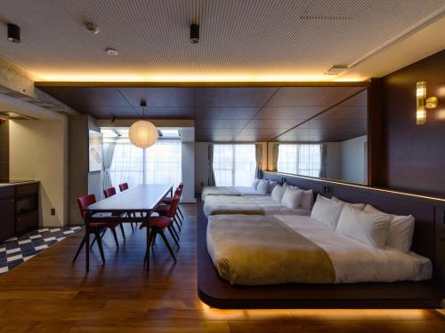 a room with a large bed and a table and chairs at illi Tex Aoyama in Tokyo
