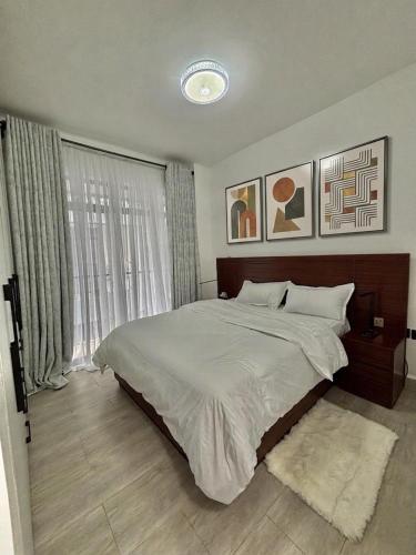 a bedroom with a large bed and a window at Apartment in Kitusuri in Nairobi