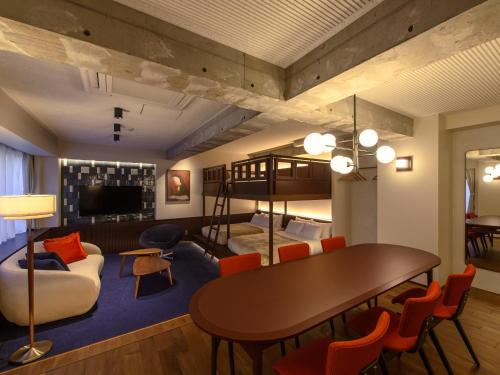 a living room with a table and chairs and a loft at illi Tex Aoyama in Tokyo