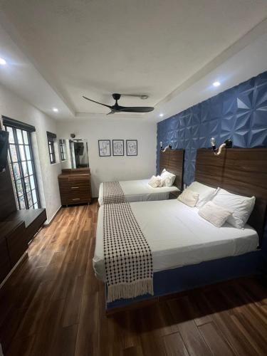 a bedroom with two beds and a blue wall at Hotel don Bosco in Guadalajara